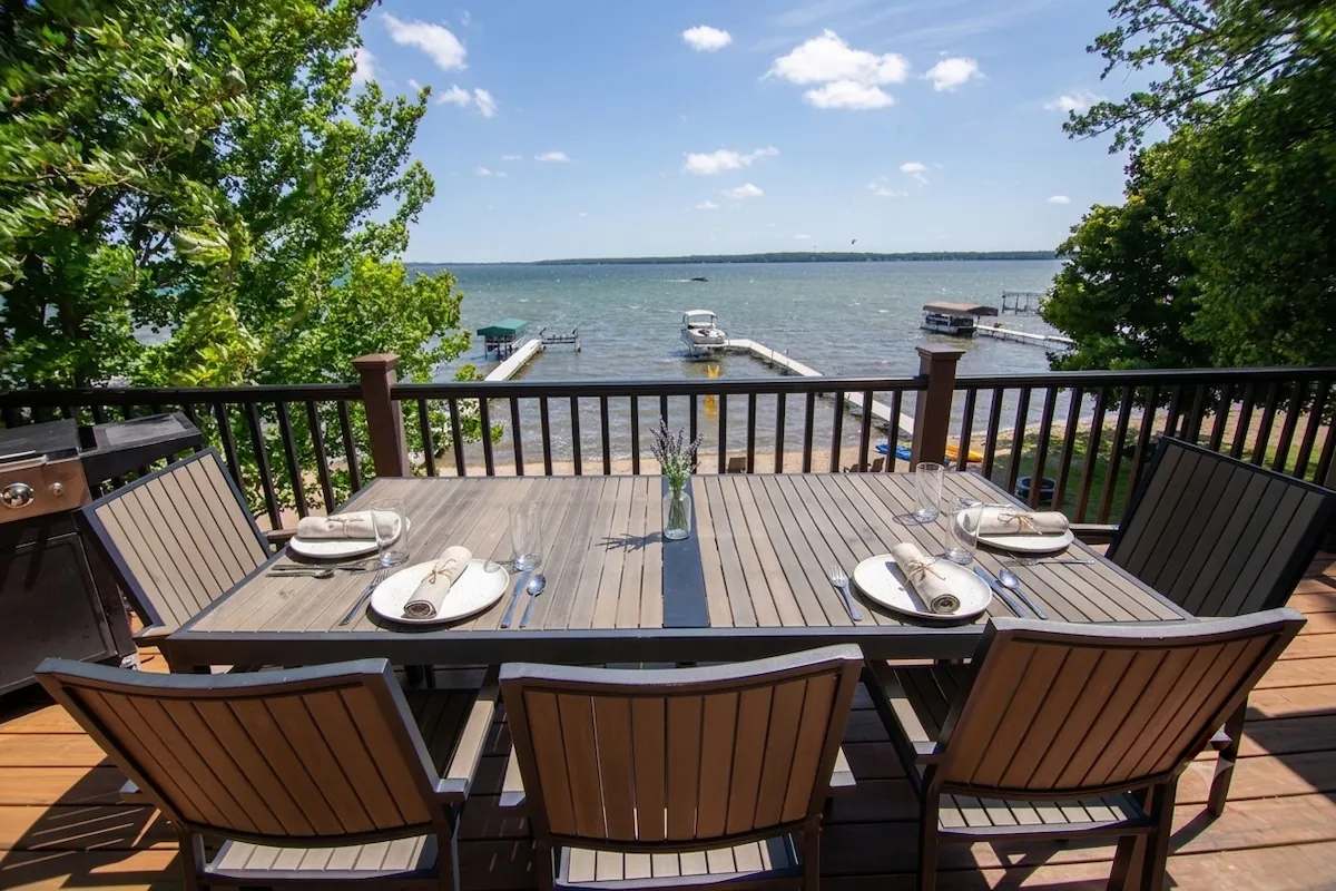 Upper deck dining table set with plates and glasses overlooking Lake Miltona